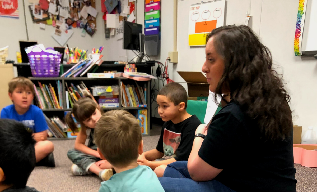 Photo of recreational therapist sitting with students in classroom