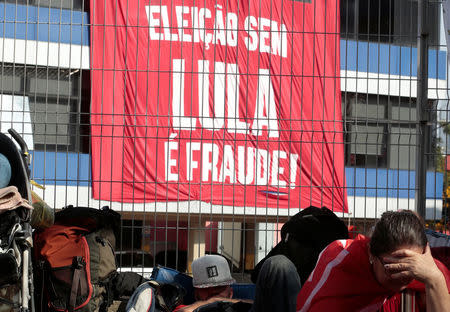 A supporter of former Brazilian President Luiz Inacio Lula da Silva reacts as they protest against the ordered Lula to turn himself in to police within 24 hours to serve a 12-year sentence for a graft conviction, in front of the metallurgic trade union in Sao Bernardo do Campo, Brazil April 6, 2018. The sign reads, "Election without Lula is fraud!". REUTERS/Leonardo Benassatto