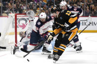 Pittsburgh Penguins' Bryan Rust (17) can't a shot off with Columbus Blue Jackets' Kirill Marchenko (86) defending in front of goalie Daniil Tarasov, left rear, during the second period of an NHL hockey game in Pittsburgh, Thursday, March 28, 2024. (AP Photo/Gene J. Puskar)