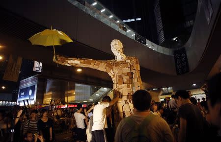 Protesters install a statue with yellow umbrella as they block the main street to the financial Central district outside of the government headquarters building in Hong Kong October 5, 2014. REUTERS/Carlos Barria