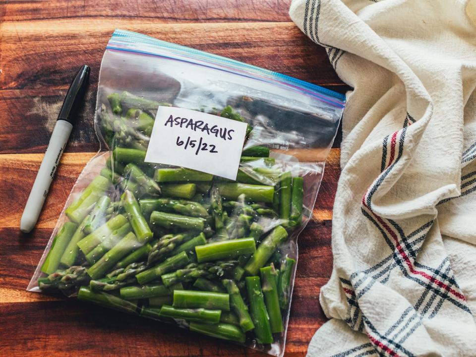 zip-top bag of asparagus pieces labeled with "asparagus 6/6/22"