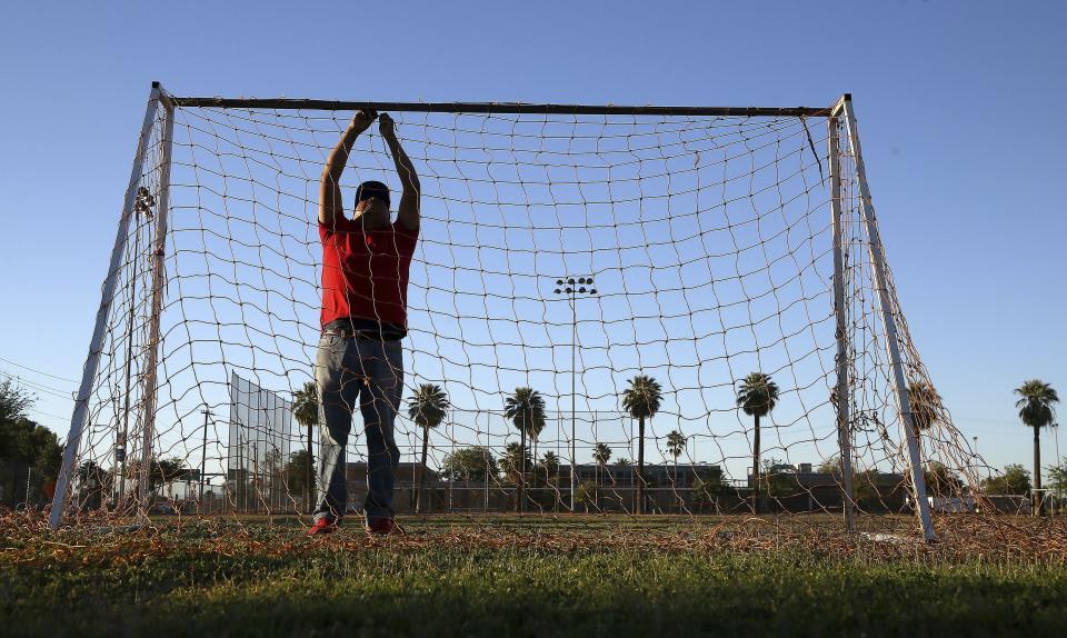 Antonio Velasquez, a pastor and director of the Maya Chapin soccer league of over 108 teams, prepares goal netting prior to several games Wednesday, April 17, 2019, in Phoenix. (AP Photo/Ross D. Franklin)