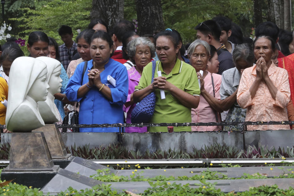 In this Saturday, Oct. 19, 2019, photo, Catholic devotees pray at the busts of Agnes Phila, front, and Lucia Khambang, two of seven martyrs at the cemetery during the 30th anniversary of their beatification at Songkhon village, in Mukdahan province, northeastern Thailand. In 1940, seven villagers here were executed for refusing to abandon their Catholic faith, which Thai nationalists had equated with loyalty to France, whose colonial army in neighboring Indochina had fought Thailand in a brief border war. The seven were beatified in 1989 by Pope John Paul II, the first step to being named a saint.(AP Photo/Sakchai Lalit)