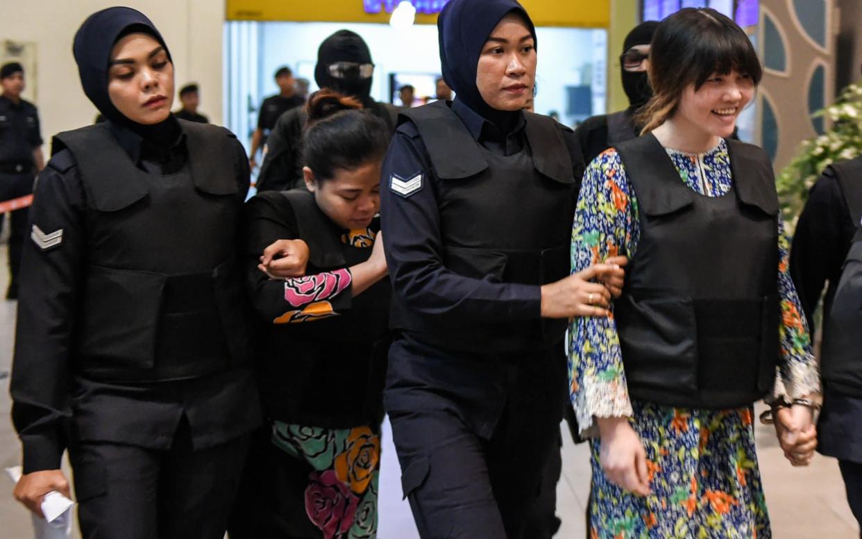 Vietnamese defendant Doan Thi Huong (R) and Indonesian defendant Siti Aishah (2nd, L) are escorted by police personnel at the low-cost carrier Kuala Lumpur International Airport 2 (KLIA2) in Sepang during a visit to the scene of the murder - AFP