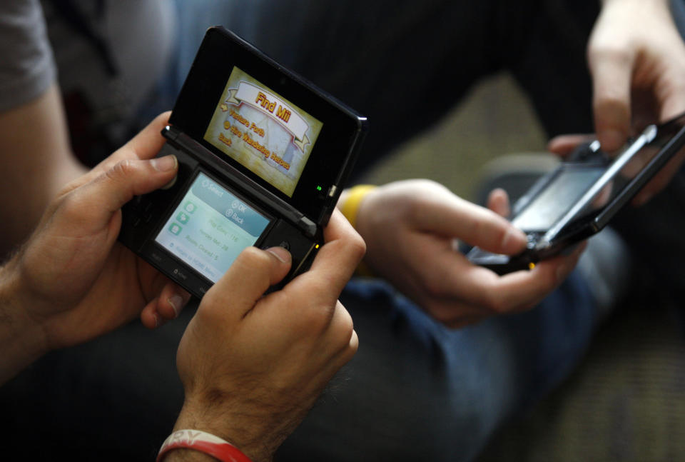 People play video games on handheld devices at the PAX East gaming conference in Boston, Massachusetts April 7, 2012. REUTERS/Jessica Rinaldi (UNITED STATES - Tags: SCIENCE TECHNOLOGY SOCIETY)