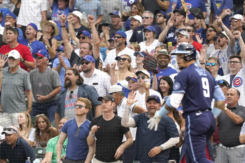 Fans celebrate after Chicago Cubs' Javier Baez hit a three-run home run during the first inning of a baseball game against the Arizona Diamondbacks in Chicago, Friday, July 23, 2021. (AP Photo/Nam Y. Huh)