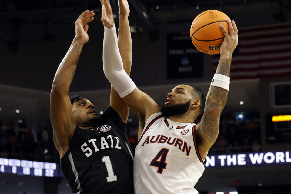 Auburn forward Johni Broome (4) shoots against Mississippi State forward Tolu Smith (1) during the second half of an NCAA college basketball game Saturday, March 2, 2024, in Auburn, Ala. (AP Photo/ Butch Dill)