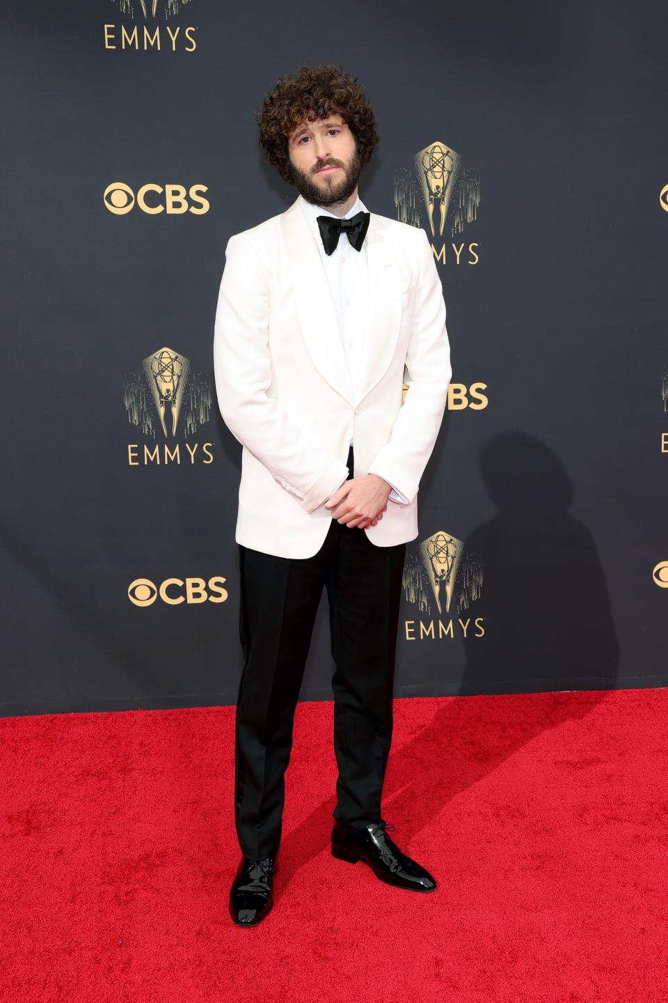 Dave Burd wears a white tuxedo jacket and black pants on the Emmys red carpet.