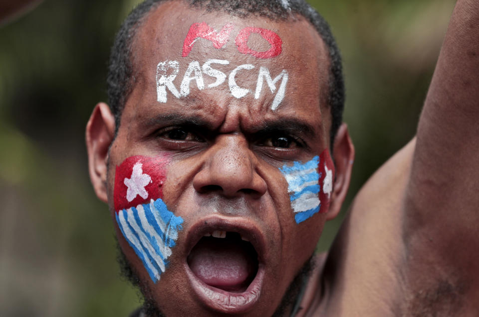 A Papuan activist with his face painted with the colors of the separatist Morning Star flag shouts slogans during a rally near the presidential palace in Jakarta, Indonesia, Thursday, Aug. 22, 2019. A group of West Papuan students in Indonesia's capital staged the protest against racism and called for independence for their region. (AP Photo/Dita Alangkara)