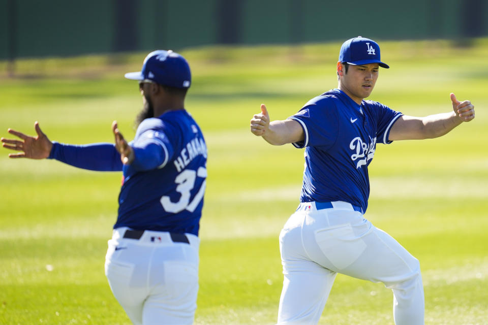 Los Angeles Dodgers designated hitter Shohei Ohtani, right, and right fielder Teoscar Hernández (37) participate in spring training baseball workouts at Camelback Ranch in Phoenix, Wednesday, Feb. 14, 2024. (AP Photo/Ashley Landis)