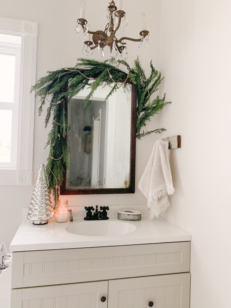 Bathroom mirror decorated with winter greenery garland