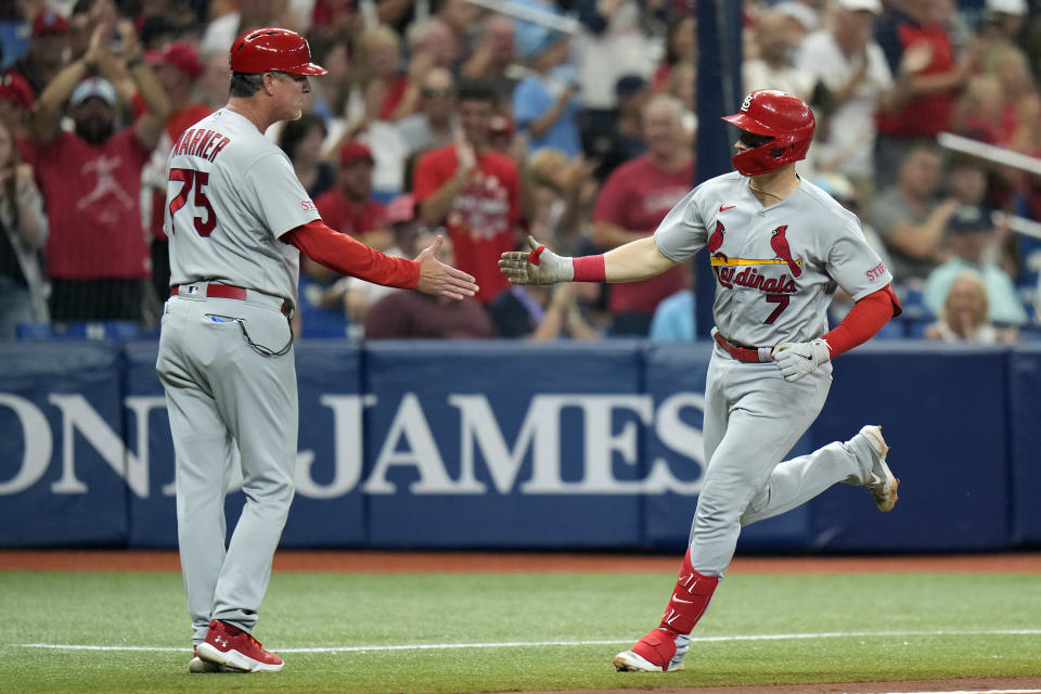 St. Louis Cardinals' Andrew Knizner (7) shakes hands with third base coach Ron 'Pop' Warner (75) after his two-run home run off Tampa Bay Rays pitcher Zack Littell during the fourth inning of a baseball game Thursday, Aug. 10, 2023, in St. Petersburg, Fla. (AP Photo/Chris O'Meara)