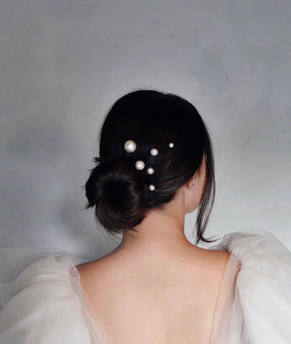 These <a href="https://www.kristinesshair.com/products/pearl-party-bobby-pins" rel="nofollow noopener" target="_blank" data-ylk="slk:Pearl Party bobby pins" class="link ">Pearl Party bobby pins</a> are the prettiest way to instantly upgrade any style, from ponytails to updos. “Pearls look incredibly chic with any hair color or texture,” says Ess. “If you’re stuck and don’t know what to do, break out the pearls!” Ess likes to scatter them randomly to create a cluster effect, then finish off with <a href="https://shop-links.co/chEW6YWTf60" rel="nofollow noopener" target="_blank" data-ylk="slk:KEH Beach Wave Spray" class="link ">KEH Beach Wave Spray</a> for extra shine.