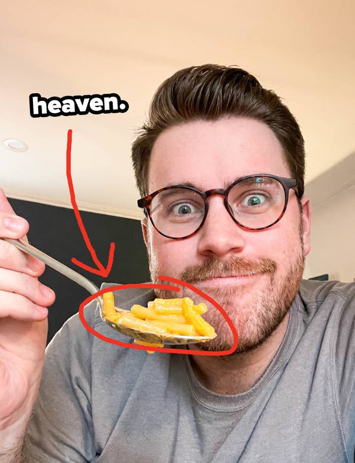 Author holding up a bite of mac 'n' cheese on a spoon with text: "heaven"