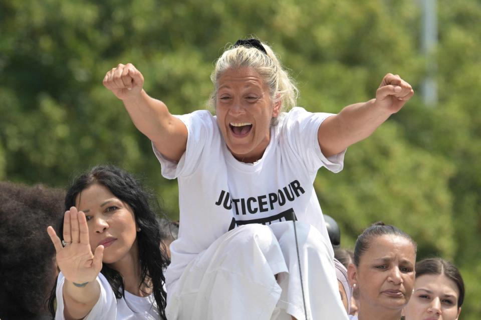 Nahel’s mother, Mounia, gestures as she sits on a truck during the march (AFP via Getty Images)