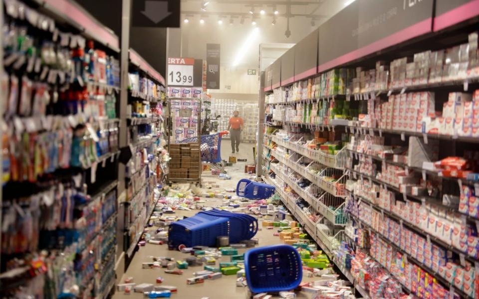 Groceries litter the floor - Andre Penner/AP