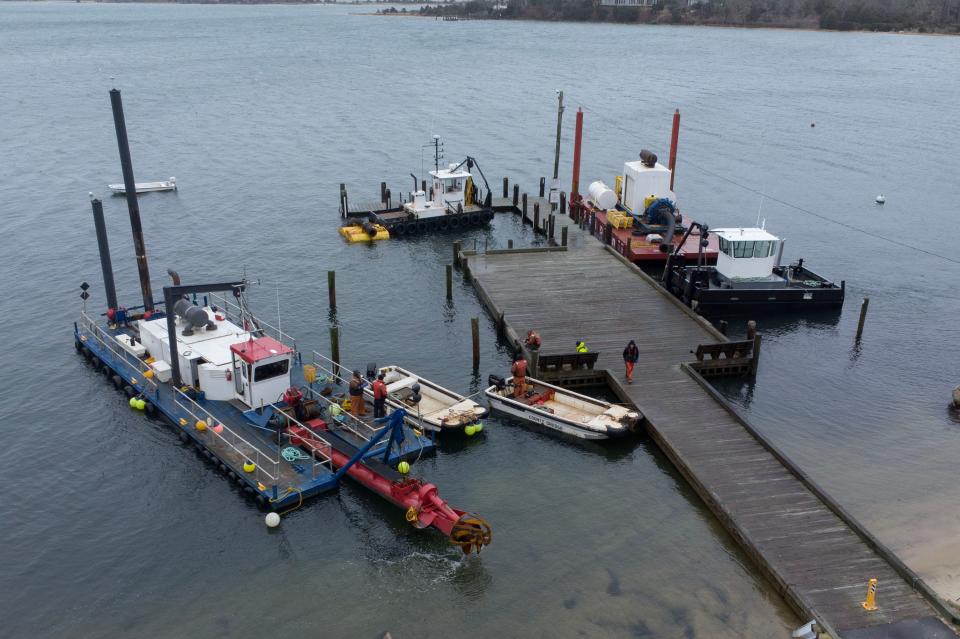 Crews ready the Barnstable County dredge, left, on Thursday along the Town Dock in Cotuit as they prepare to start a project at the Cotuit Bay entrance. The materials from the project will be used for beach nourishment at the eastern end of Dead Neck.