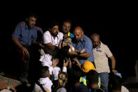 <p>Italian Carabinieri police officer and a doctor carry a child after an earthquake hit the island of Ischia, off the coast of Naples, Italy, Aug. 22, 2017. (Photo: Antonio Dilaurenzo/Reuters) </p>