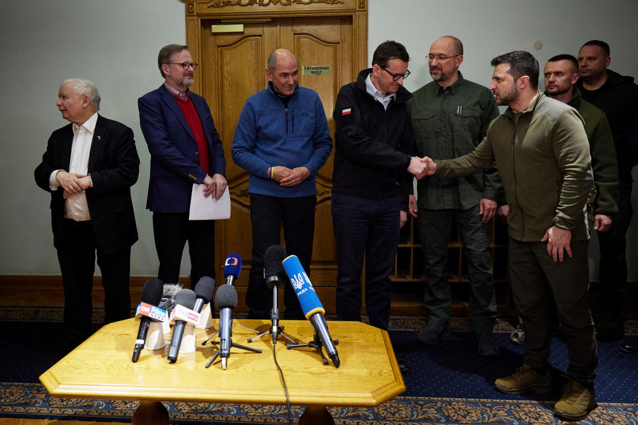 All standing in front of a table with microphones, Volodymyr Zelenskiy shakes hands with Polish Prime Minister Mateusz Morawiecki during a joint news briefing with Ukrainian Prime Minister Denys Shmygal, Czech Prime Minister Petr Fiala, Slovenian Prime Minister Janez Jansa and Polish Deputy Prime Minister Jaroslaw Kaczynski.