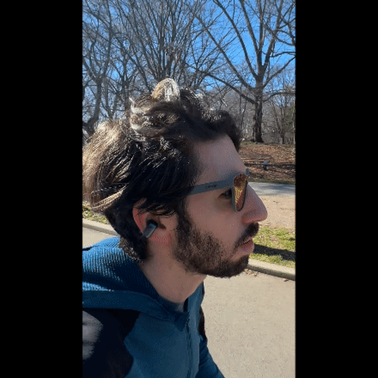 Close-up of the reporter running outdoors in a park with the Bose Ultra Open Earbuds and a pair of sunglasses on. (Courtesy Harry Rabinowitz)