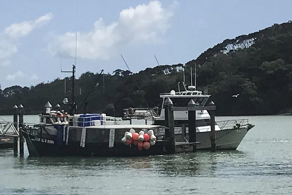 This photo shows a charter fishing boat, right, operated Enchanter Fishing Charters, at the Mangonui Wharf in Mangonui, New Zealand,.