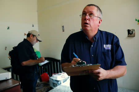 Bob Friedl (R), a senior project manager, and Marco Perdone, president, with Environmental Management Solutions of New York Inc., survey the apartment of Natalia Rollins for lead in the Coney Island section of the Brooklyn borough of New York, U.S., October 27, 2017. REUTERS/Shannon Stapleton/Files