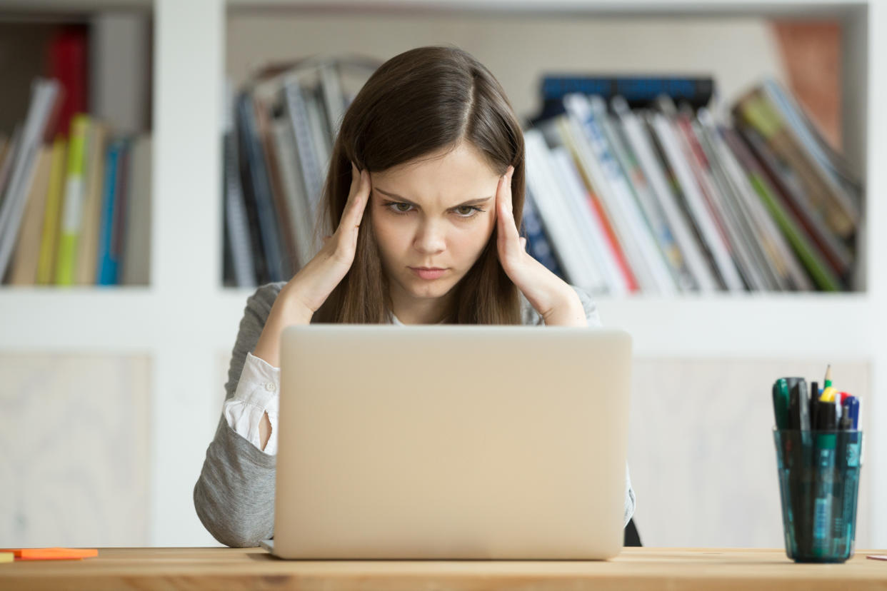 Focused concerned student learning difficult homework assignment with laptop online, concentrated girl preparing for digital exam on pc, serious young woman thinking hard on task with computer