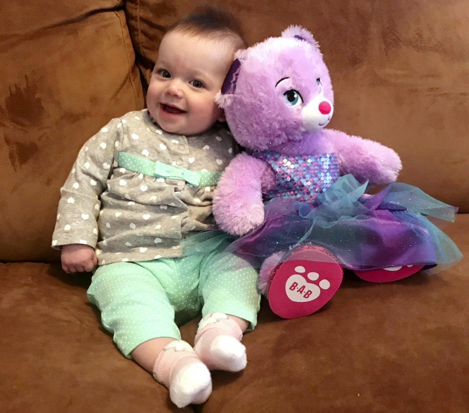 9-month-old Ailsa Polo poses next to a teddy bear in the Polos’ home in Duluth, Minnesota. Polo named his daughter Ailsa after Ailsa Craig, the Scottish island where the granite for curling rocks is mined. (Joe Polo via AP)