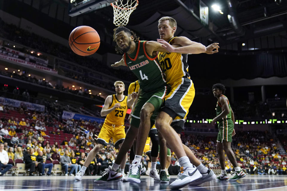 Florida A&M guard Hantz Louis-Jeune (4) fights for a loose ball with Iowa forward Payton Sandfort (20) during the first half of an NCAA college basketball game, Saturday, Dec. 16, 2023, in Des Moines, Iowa. (AP Photo/Charlie Neibergall)