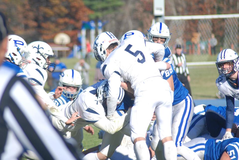 St. Thomas Aquinas' Trent Salyards (7) and and Sam Grondin (5) combine for a tackle during a Division II semifinal in Pelham. Both were named Division II all-state players this season.