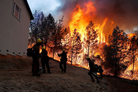 FILE PHOTO: A group of U.S. Forest Service firefighters monitor a back fire while battling to save homes at the Camp Fire in Paradise, California, U.S. November 8, 2018. REUTERS/Stephen Lam/File Photo