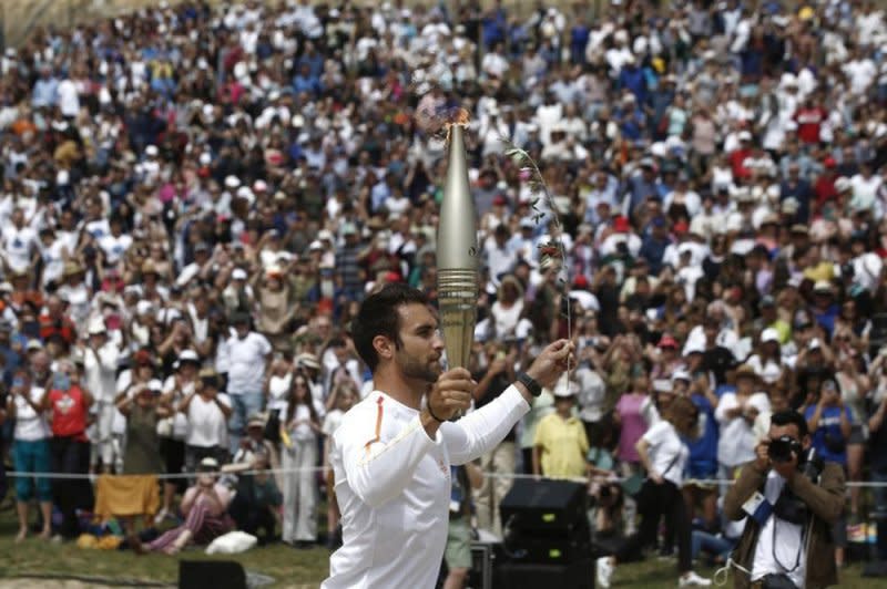 Greek Olympic gold medalist Stefanos Ntouskos begins the first leg of the 3,100-mile Olympic torch relay that began at the ancient stadium in Olympia early Tuesday and ends at the site of the 2024 Olympic Games in Paris. Photo by Yannis Kolesidis/EPA-EFE