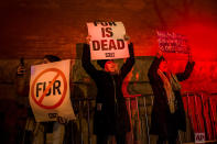 <p>Animal right activists are lit by flashing police lights as they protest outside Marc Jacobs fashion show during Fashion Week in New York. (AP Photo/Andres Kudacki) </p>