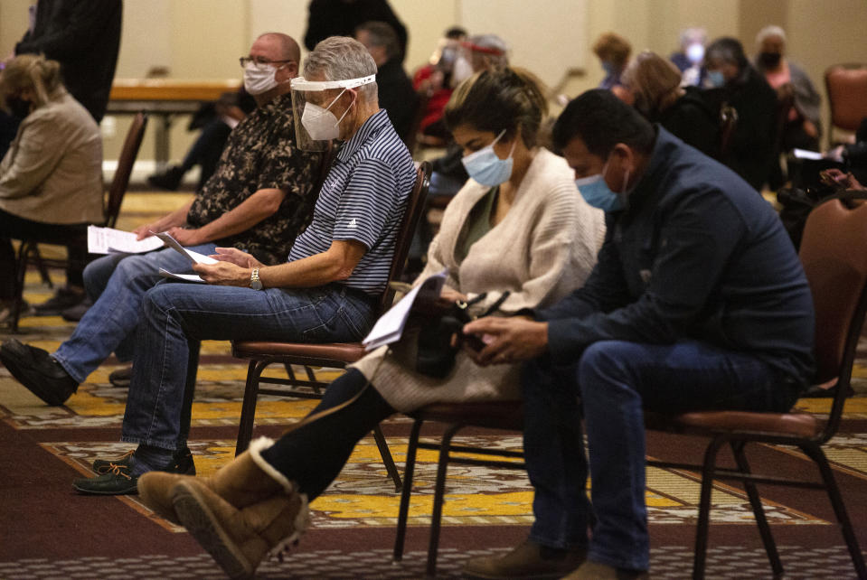 People who qualify under Phase 1A or Phase 1B of the state's guidelines waiting to receive the COVID-19 vaccine Sunday, Jan. 3, 2021, at a Houston Health Department's COVID-19 vaccine clinic in Houston. The department vaccinated 1,008 people who qualify under Phase 1A or Phase 1B of the state's guidelines at the clinic's first day on Saturday. (Yi-Chin Lee/Houston Chronicle via AP)