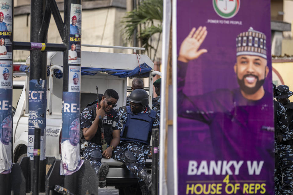 Nigerian police sit in the back of a truck as they protect a collation center which was engaged in collating results manually, in Lagos, Nigeria, Sunday, Feb. 26, 2023. People were still voting across Nigeria Sunday morning, the day after Africa's most populous nation was supposed to have completed elections, as logistical and security challenges caused widespread delays. (AP Photo/Ben Curtis)