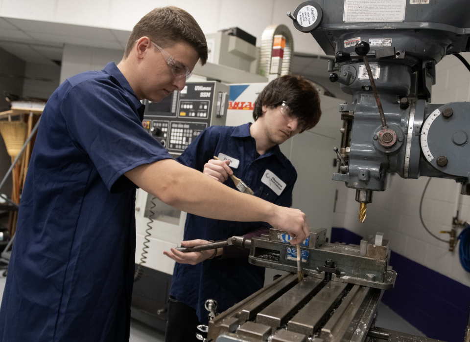Maxym Prydii, 16, and Zach Kaisk, 17, clean a machine at Barberton High School.