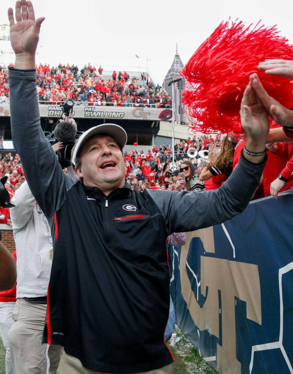 Georgia Bulldogs head coach Kirby Smart high fives fans after a victory against the Georgia Tech Yellow Jackets at Bobby Dodd Stadium.