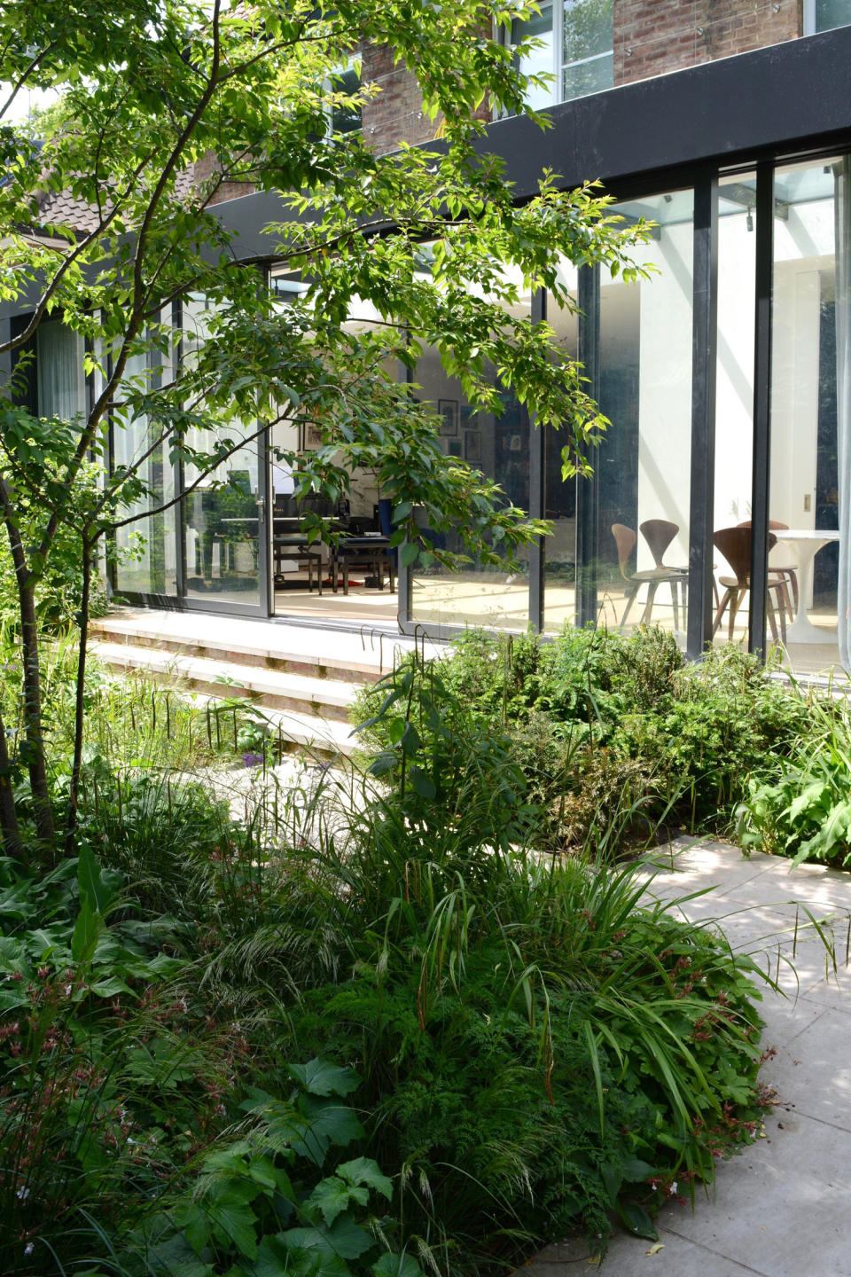 a lush garden space and a glass-covered seating area