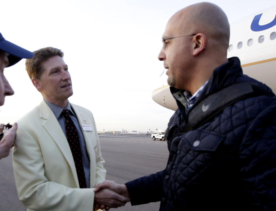 FILE - In this Dec. 23, 2017, file photo, Penn State head coach James Franklin, right, is greeted by Fiesta Bowl executive director Mike Nealy in preparation for an upcoming NCAA college football bowl game against Washington in Phoenix. Nealy and the Fiesta Bowl organizing committee faced unique challenges this year running two games. The Fiesta Bowl, one of the New Year's Six bowl games, went off as planned but the Guaranteed Rate Bowl, which was scheduled for Dec. 26, 2020, was canceled after there weren't enough teams to fill all of the bowl spots. (AP Photo/Rick Scuteri, File)