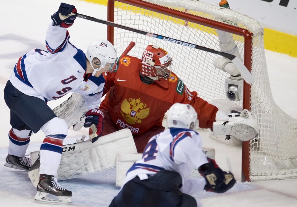 United States' Joel Farabee and Josh Norris try to get a shot on Russia goalie Pyotr Kochetkov during the second period of a world junior hockey championships semifinal in Vancouver, British Columbia, Friday, Jan. 4, 2019. (Jonathan Hayward/The Canadian Press via AP)