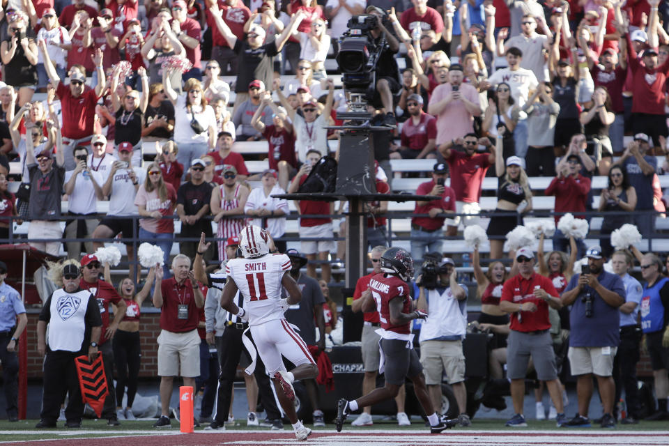 Fans react as Washington State wide receiver Kyle Williams (2) runs for a touchdown past Wisconsin cornerback Alexander Smith (11) during the first half of an NCAA college football game, Saturday, Sept. 9, 2023, in Pullman, Wash. (AP Photo/Young Kwak)