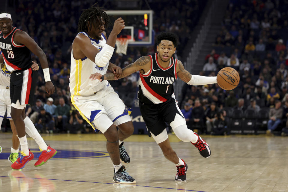 Portland Trail Blazers guard Anfernee Simons (1) drives against Golden State Warriors forward Kevon Looney during the first half of an NBA basketball game in San Francisco, Wednesday, Dec. 6, 2023. (AP Photo/Jed Jacobsohn)