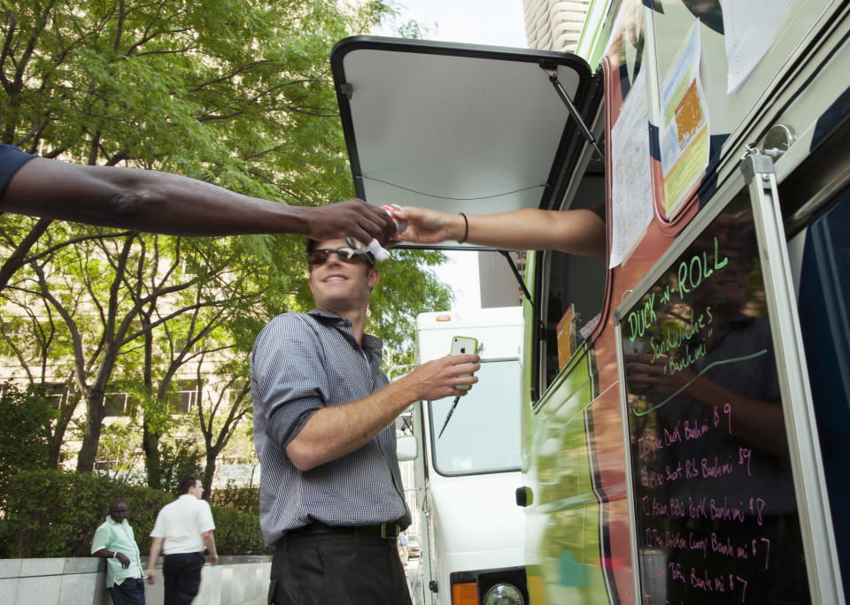 FILE - In this July 12, 2012 file photo, a customer purchases a drink from the Duck N Roll food truck in downtown Chicago. On Wednesday, July 25, 2012, the Chicago City Council is expected to take up an ordinance that would allow chefs to cook and prepare food onboard the trucks and creates parking zones around the city. Chicago, known for its high-end restaurants, has lagged behind other cities when it comes to joining the food truck craze. (AP Photo/Sitthixay Ditthavong, File)