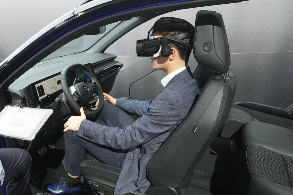 A visitor experiences a virtual tour of the new SUV Renault Austral E-Tech full hybrid at the Paris Car Show Monday, Oct. 17, 2022 in Paris. Europe is leading the charge into electric vehicles as battery powered cars break out of their niche market of first adopters and enter the mainstream with increasing market share that's forecast to grow strongly as the EU pushes to phase out internal combustion engine vehicles by 2035 (AP Photo/Michel Euler)