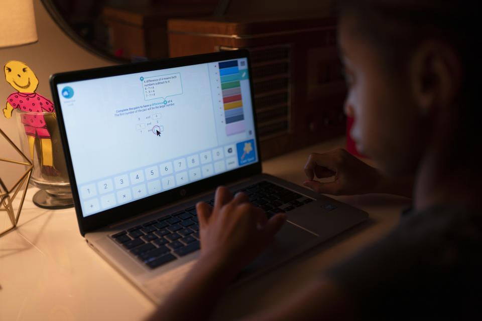 Abigail Schneider, 8, completes a level of her learning game on a laptop computer, Wednesday, Dec. 8, 2021, in the Brooklyn borough of New York. "I'm determined to push and push to get them the things that help them," said April Schneider. "I have to go above and beyond to make sure whatever requirements they need they get." (AP Photo/John Minchillo)