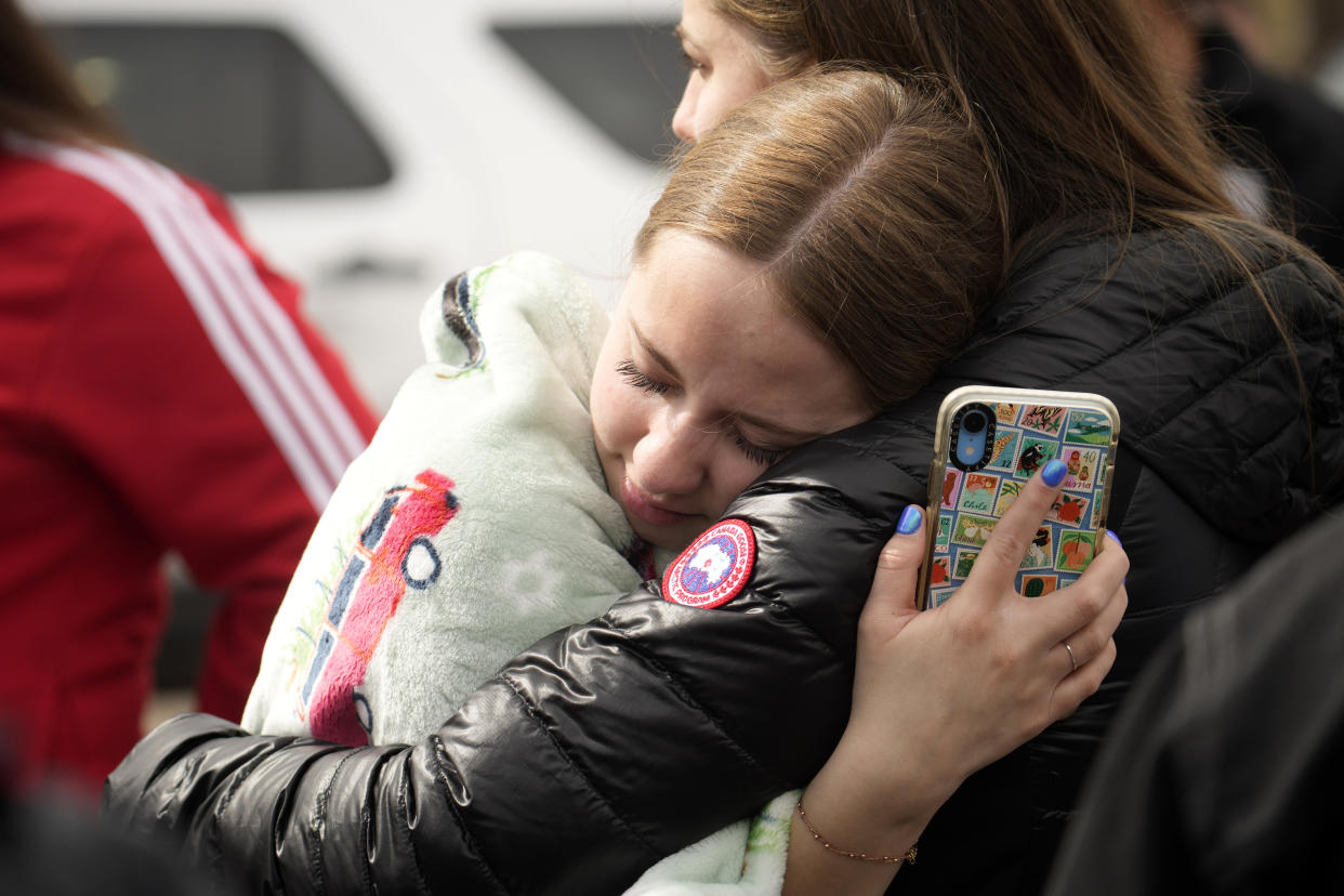 Two women hug when reunited following a shooting at East High School, Wednesday, March 22, 2023, in Denver. (AP Photo/David Zalubowski)