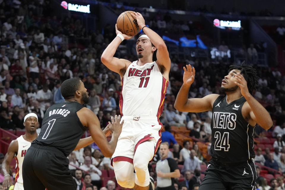 Miami Heat forward Jaime Jaquez Jr. (11) goes up for a shot against Brooklyn Nets forward Mikal Bridges (1) and guard Cam Thomas (24) during the first half of an NBA basketball game, Wednesday, Nov. 1, 2023, in Miami. (AP Photo/Wilfredo Lee)