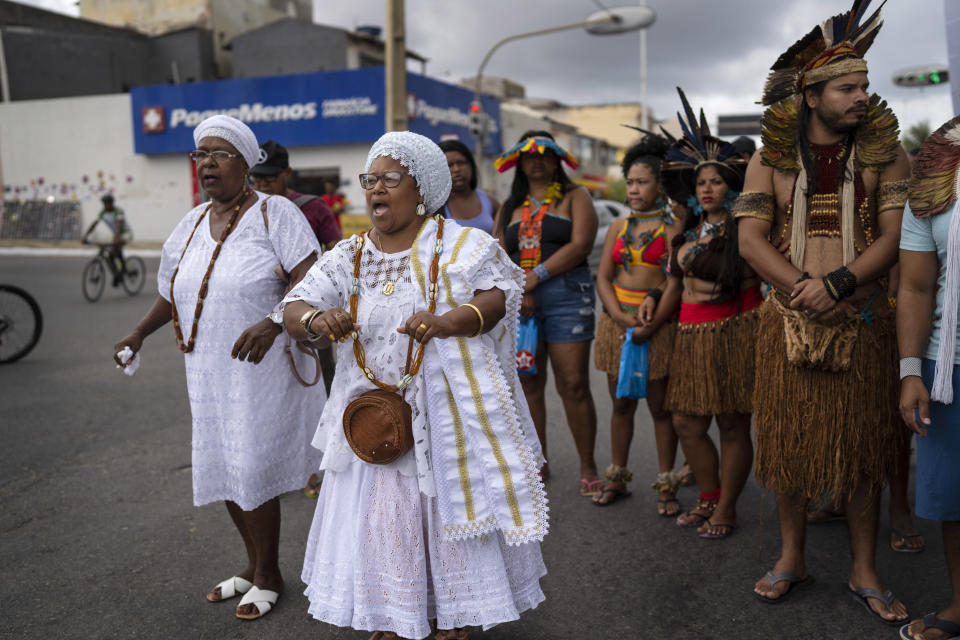 Members of the Indigenous community join Afro Brazilian community members in a protest march, in Salvador, Brazil, Sunday, Sept. 18, 2022. Protesters called on authorities to take action against projects that would have environmental impact on the dunes, including one to accommodate evangelical pilgrims congregating at the Abaete dune system, an area members of the Afro Brazilian faiths consider sacred. (AP Photo/Rodrigo Abd)