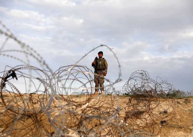 An Afghan National Army (ANA) soldier stands guard at a checkpoint outside Bagram prison, ahead of the release of 100 Taliban prisoners, north of Kabul