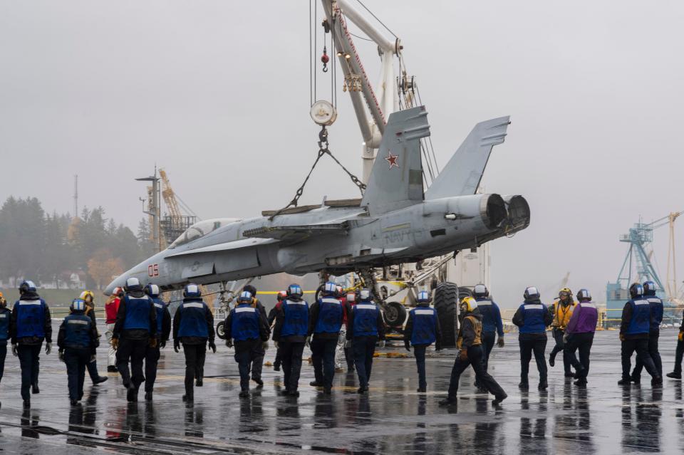 Sailors transport an F-18 training jet onto the flight deck during a fast cruise aboard the aircraft carrier USS Nimitz (CVN 68). The fast cruise consists of equipment tests, simulations, scenarios, which refresh and train Sailors for underway periods. Nimitz is currently undergoing a planned incremental availability maintenance period at Puget Sound Naval Shipyard.